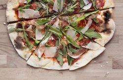 Sliced thin-crust pizza with arugula